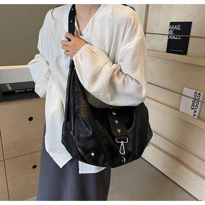 Gros plan d'un sac en cuir noir grainé avec des rivets en étoile et des garnitures argentées