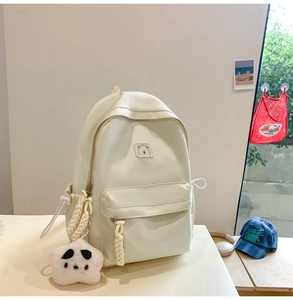 Close-up of cream white PU leather backpack with cute bear patch and plush star charm