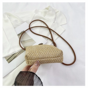 Close-up of woven straw texture and base detail of minimalist summer crossbody bag