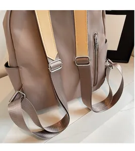 Detail of adjustable nylon shoulder straps and smooth zipper pocket on the taupe backpack