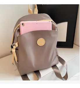 Detailed view of the nylon backpack showing front pocket storage for a tablet device