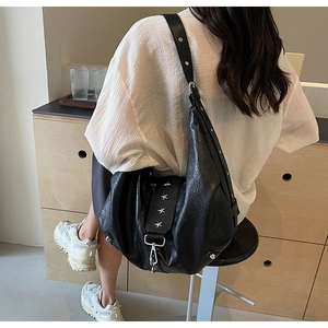 Vue latérale du grand sac hobo noir avec rivets en étoile sur cuir synthétique texturé