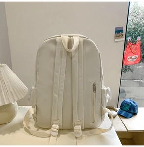 Minimalist beige backpack back view showing adjustable padded straps and anti-theft zipper pocket