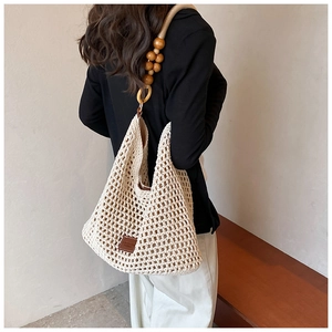Détail du sac fourre-tout crème tissé à la main avec bandoulière distinctive en perles de bois
