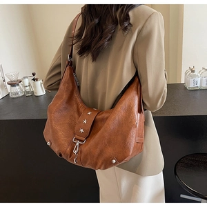 Détail du sac en cuir caramel avec rivets étoiles argentés et fermoir mousqueton chic