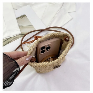 Top view of straw crossbody bucket bag showing interior space for phone and lipstick