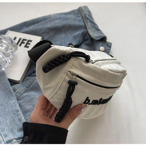 Dettaglio della borsa a tracolla in nylon bianco con ricamo nero e spessa zip intrecciata