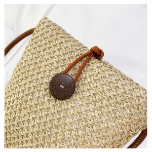 Detailed close-up of woven straw bag texture and brown coconut shell button clasp