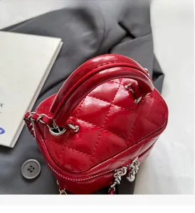 Close-up of red quilted leather handbag with metallic chain strap and top handle
