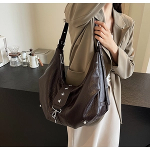 Détails du sac hobo marron foncé avec texture cuir vintage et rivets en étoile