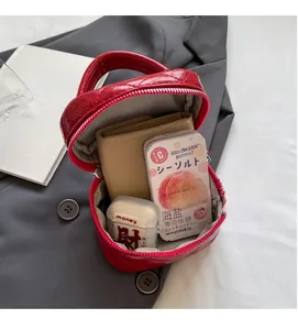 Internal view of red quilted bag showing storage capacity for headphones and wallet