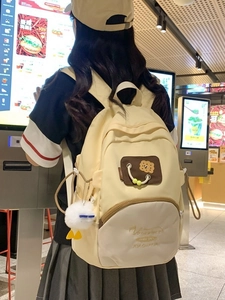 Beige canvas backpack for women featuring cute duck pendant and casual design for travel