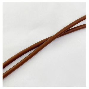 Detail of brown litchi textured leather strap and precise stitching on crossbody bag