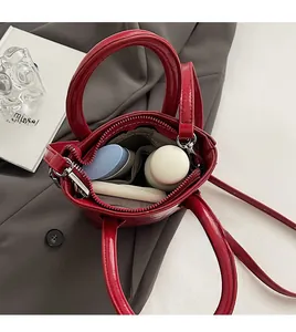 Top-view detail of a red leather bucket bag showing large interior capacity and grey lining