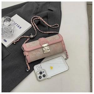 Detail of pink jacquard cylinder bag with embroidery, leather trim, and silver M-lock