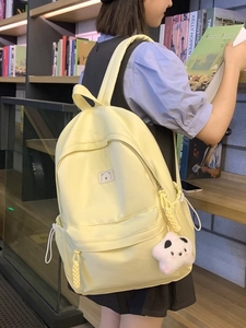 Minimalist light yellow aesthetic backpack for students with a plush panda charm