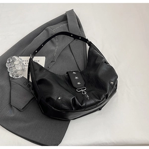 Détail du sac en similicuir plissé noir avec rivets étoiles argentés et décoration