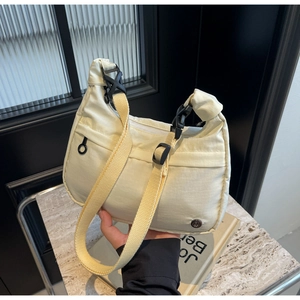 Détail du sac en toile blanc cassé avec bandoulière jaune et boucle en plastique