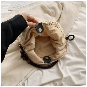 Detail view of woven beach bag interior featuring a metal zipper pocket and magnetic buckle