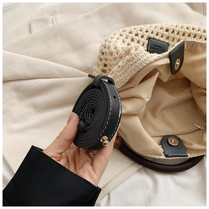 Vue détaillée du sac en paille tissée avec doublure, boucle magnétique et bandoulière