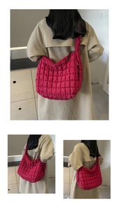 Detail view of pink quilted puffer shoulder bag showing square stitching and wide strap