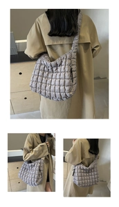 Detail view of a gray quilted puffy shoulder bag with large diamond stitching texture