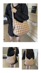 Detail of beige quilted puffer bag featuring a soft grid pattern and wide shoulder strap