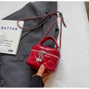 Detail of red quilted mini box bag with silver heart charms and chain strap