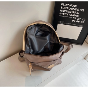 Detailed interior view of a brown nylon backpack with inner zipper pocket and gray lining