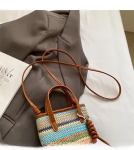 Detail of bohemian woven mini bag with colorful patterns and brown leather strap