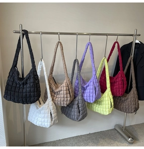 Multiple quilted puffy cloud bags in various colors displayed on metal hangers