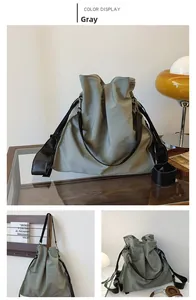 Detail view of large gray nylon tote bag with drawstring folds and black shoulder strap