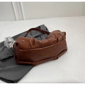 Vue détaillée de la texture en similicuir plissé marron avec boucles en argent