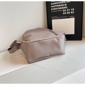 Detail of light brown nylon backpack with water-resistant fabric and silver metal zipper
