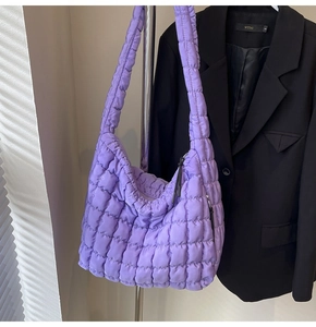Close-up of a taro purple quilted cloud bag hanging on a rack with padded texture