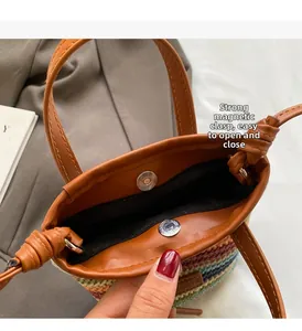 Detail of bohemian straw bag featuring strong magnetic closure and brown leather handles