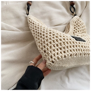 Gros plan détaillé d'un sac cabas tissé beige avec des perles décoratives en bois brun