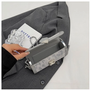 Detail of grey vintage embossed square bag with silver chain and metal lock closure