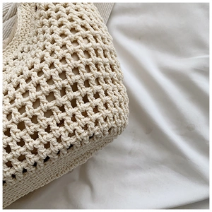 Gros plan détaillé de la texture en paille tressée du sac cabas avec maille