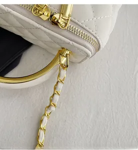Detailed macro view of gold hardware zipper and quilted texture on white handbag