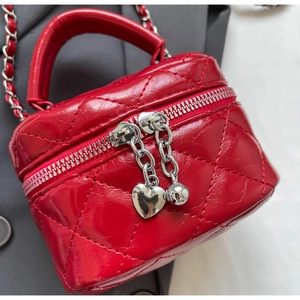 Macro shot of red quilted mini vanity bag with silver heart zipper pulls and chain strap