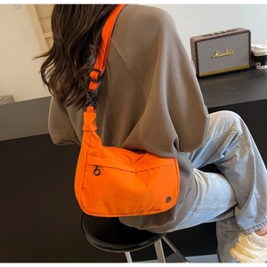 Détail du sac bandoulière croissant orange vif avec sangle réglable et boucle robuste