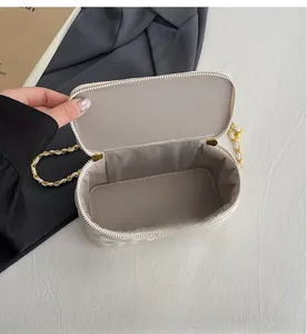 Interior view of white quilted cosmetic bag showing grey herringbone lining and zipper