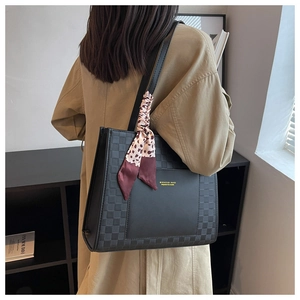 Detail of black tote bag with checkered embossing and leopard print silk scarf