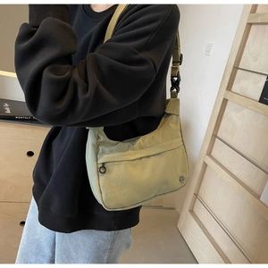 Détail du sac croissant en nylon vert pois avec bandoulière réglable et poche zippée