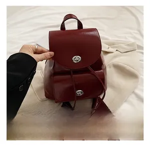 Detailed view of dark red oil wax leather backpack with vintage metallic twist lock