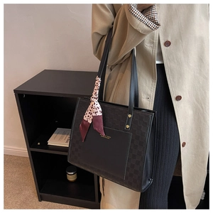 Detail of black tote bag with checkered panels and a stylish printed silk scarf handle