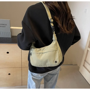 Détail du sac croissant en nylon vert clair avec bandoulière réglable et logo