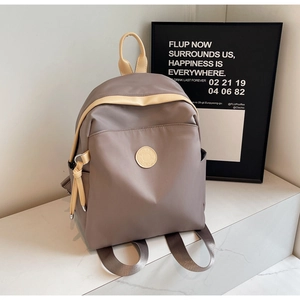 Detail view of stylish grey nylon backpack with beige handles on marble background