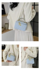 Detail of light blue quilted leather vanity bag with gold flower clasp and metal handle